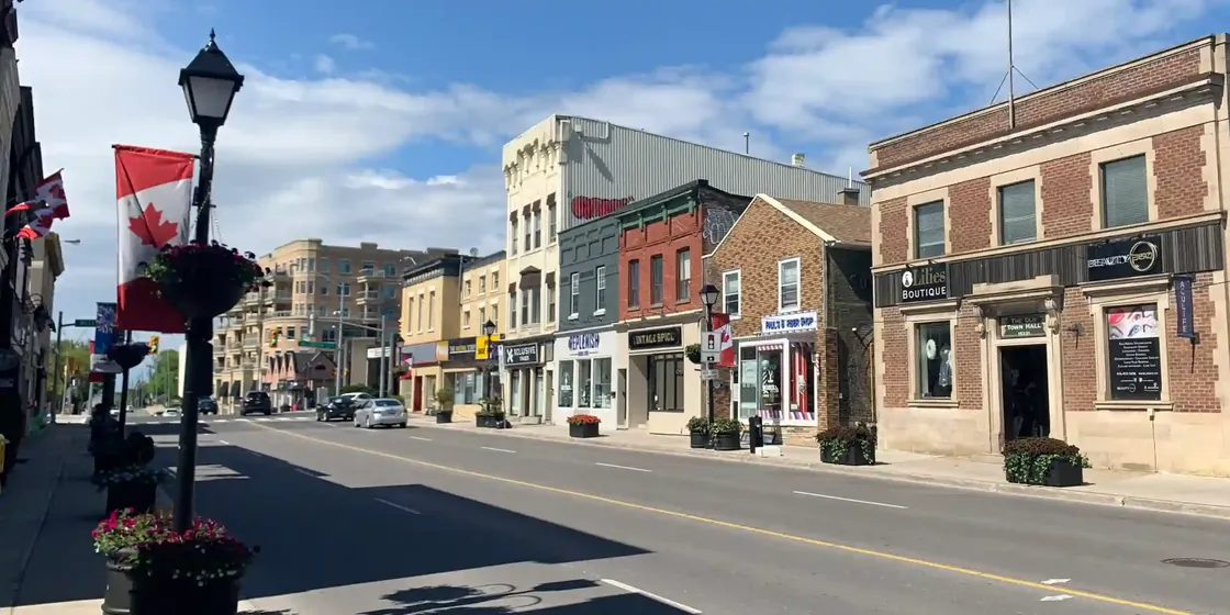Main street of a small Ontario town with brick storefronts and a Canadian flag